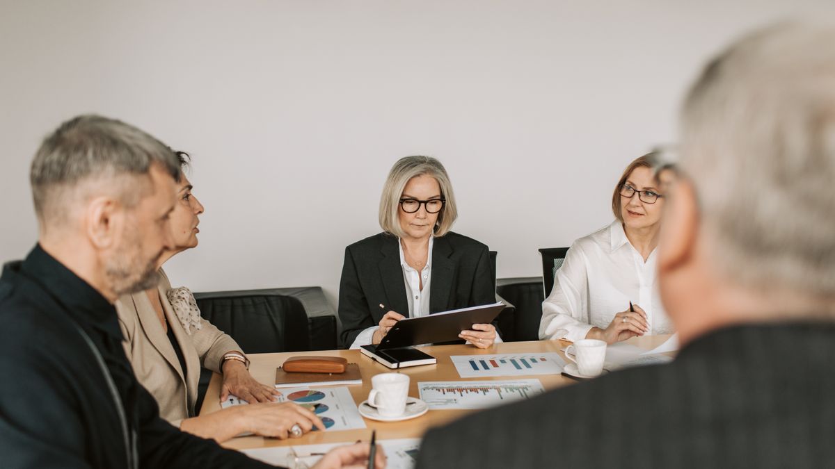 Sócios de uma empresa reunidos em volta de uma mesa de escritório