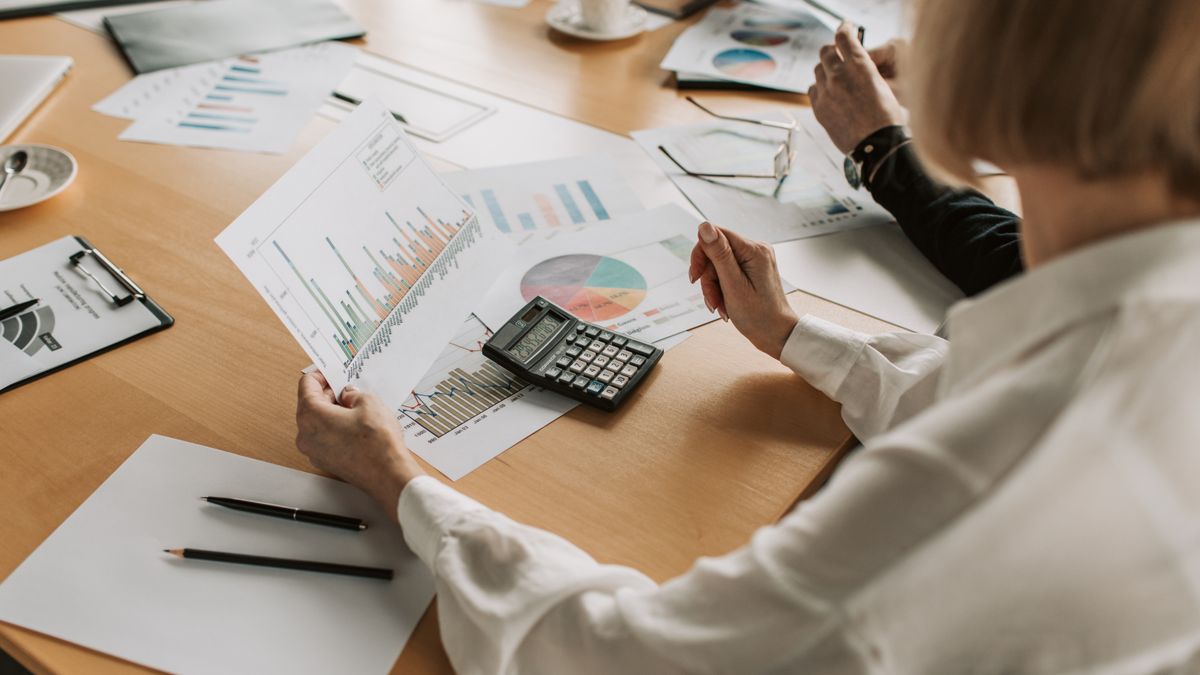 Equipe analisando gráficos e relatórios de empresas segmentadas por setor econômico